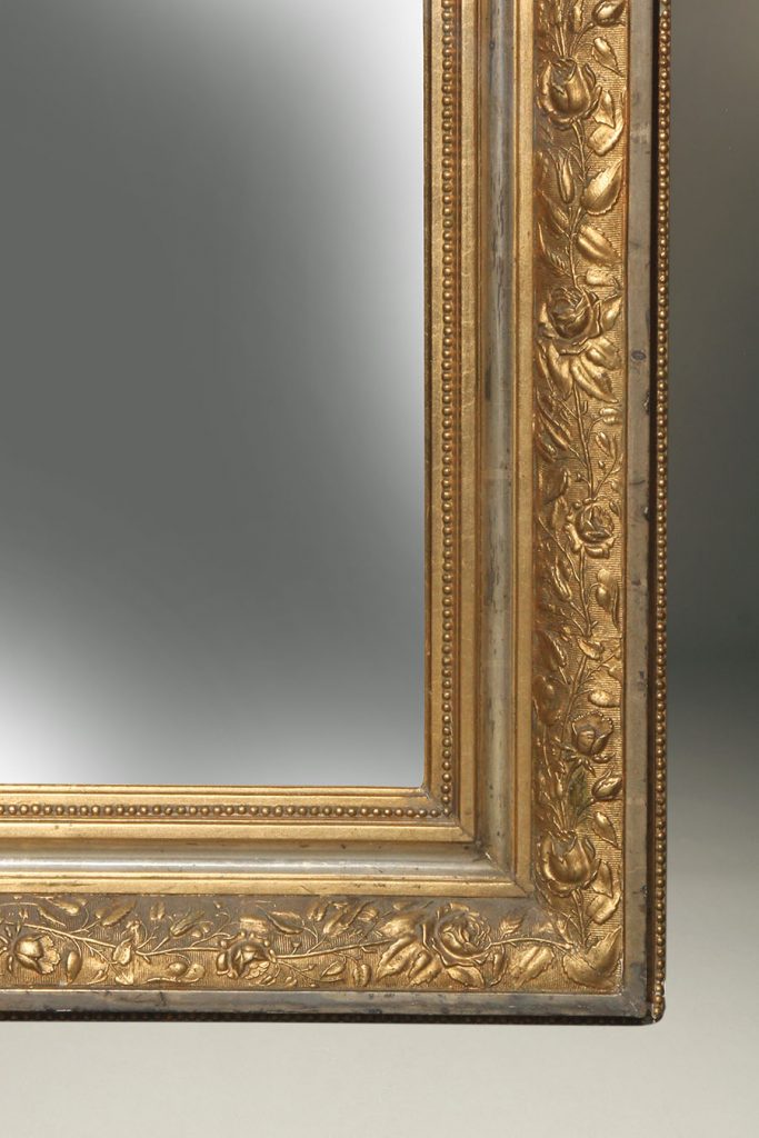 Antique French beveled mirror with a very ornate gilded frame.